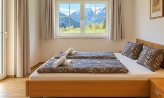 A cozy bedroom with a double bed and beautiful pillows. Large windows offer a view of the mountains and the green countryside outside.
