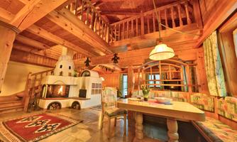 A cozy living space made of wood with an open gallery. A dining table and a seating area invite you to linger, while a fireplace provides warmth.