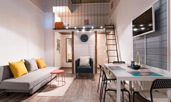 A modern apartment with a cozy living room and a dining area. The wooden staircase leads to an upper floor, and the decor is minimalist and inviting.