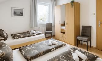A modern bedroom with two beds and a wardrobe. Bright colors and plant patterns create a pleasant atmosphere.