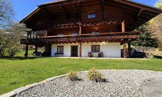 A spacious wooden house with a beautiful balcony. The garden is green and well-maintained, ideal for relaxing days outdoors.
