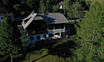 A beautiful house surrounded by trees in a quiet landscape. The balcony offers a view of nature.