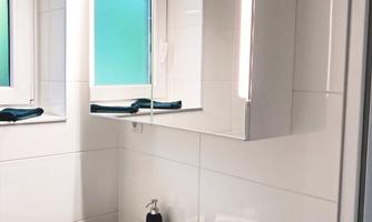 Bright bathroom with a large mirrored cabinet, sink, and stylish details for a comfortable start to the day.