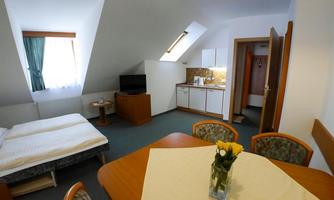 A bright, friendly accommodation with one bedroom and a small kitchen. The dining area is furnished with a table and chairs.