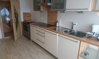 A modern kitchen with wood and stainless steel accents. It is well-equipped and offers plenty of storage space.
