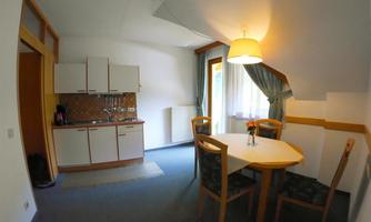A bright kitchen with a dining area. The table is decorated with a blooming plant.