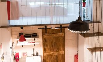 A modern kitchen with wooden details and elegant lighting. The open design and bright colors create an inviting atmosphere.