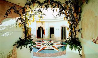 An elegant interior with botanical elements and artistic decorations. The floor features a symmetrical pattern in vibrant colors.