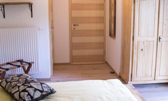 A cozy bedroom with two beds and yellow bedding. The room has a bright atmosphere with wooden details and modern lighting.