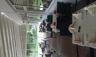 An elegant restaurant with tables and chairs. The large window front offers a view outside.