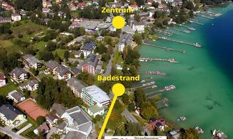 An aerial photo of a city with a clear lake and a bathing area. The surroundings show residential buildings and green spaces.