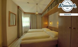 A cozy bedroom with two single beds and soft lighting. Large windows provide plenty of daylight and a relaxed atmosphere.