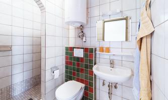 A modern bathroom with a shower, toilet, and sink. The tiles are designed in various colors.