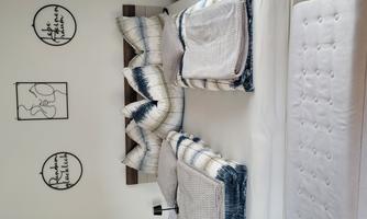 A cozy quiet bedroom with a large bed and decorative pillows. Modern round pictures hang on the wall.
