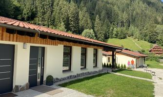 Modern buildings in a green mountainous landscape. A clear blue sky and a calm environment create a relaxed atmosphere.