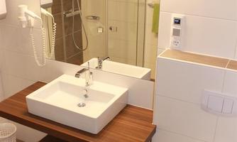 A modern bathroom with an elegant sink installation and a large mirror. The design is bright and minimalist.