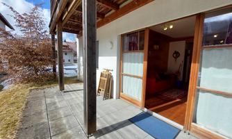 A cozy outdoor area with a terrace and access to a bright living space. The surroundings are quiet with a beautiful view of nature.