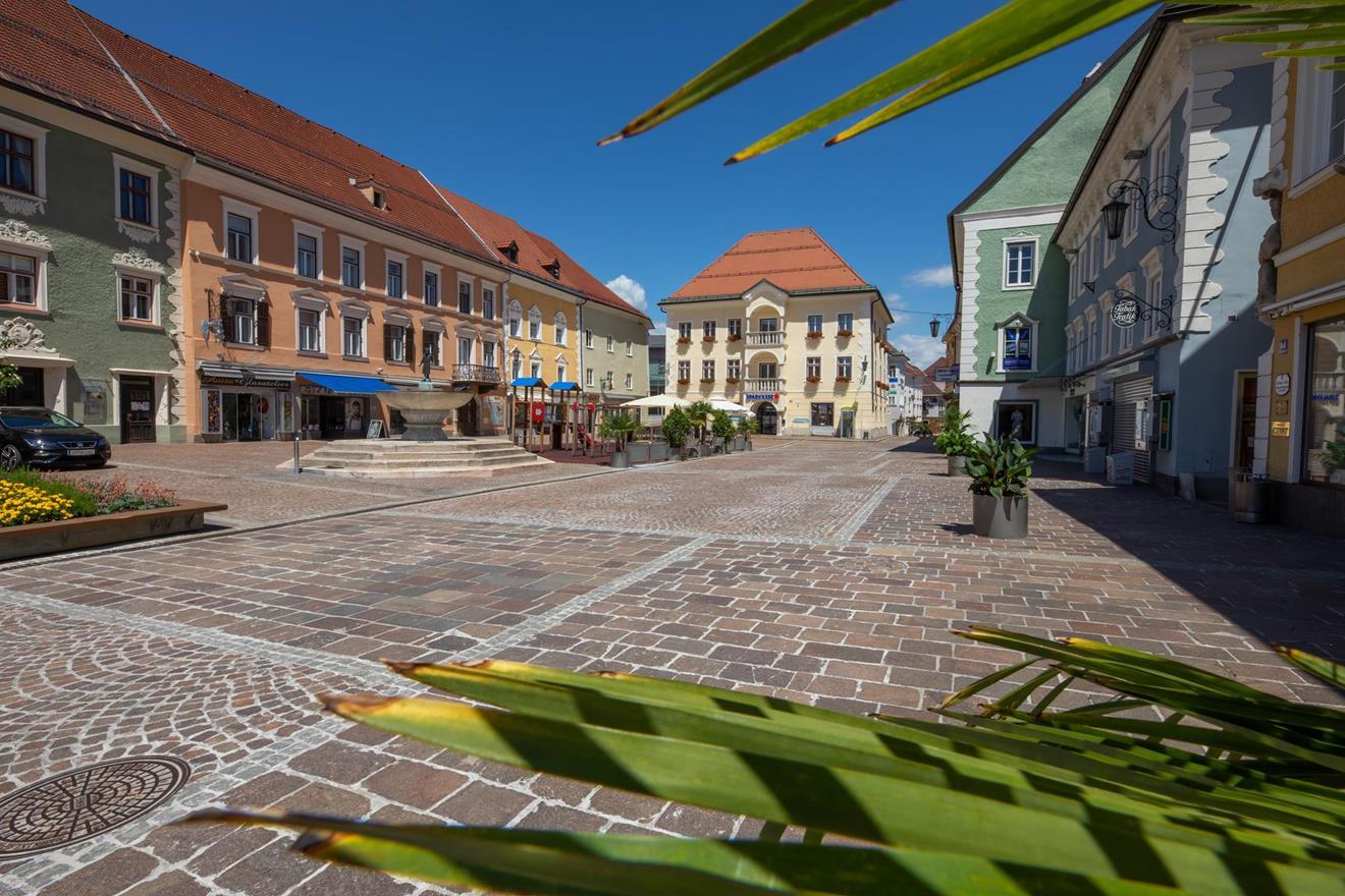 Platz mit Brunnen und bunten Häusern in Feldkirchen in Kärnten, Österreich