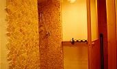 A modern shower with stone walls and gentle lighting. The space feels inviting and relaxing.