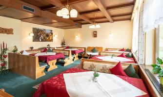 An inviting restaurant with rustic decor. The tables are adorned with red tablecloths and fresh flowers.