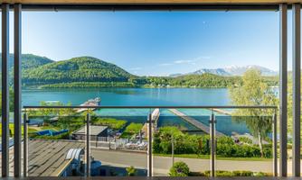 A beautiful view of a clear lake surrounded by green hills. The landscape is peaceful and inviting.
