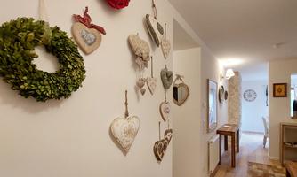 An inviting hallway with decorative hearts and a green garland on the wall. The room is designed to be bright and friendly.