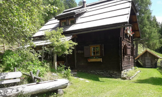 A charming wooden house surrounded by trees and meadow. The rustic architecture harmonizes with the natural surroundings.