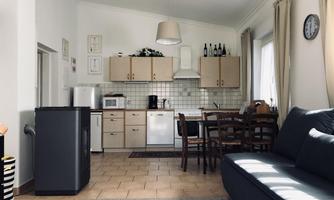 A bright and welcoming kitchen with modern appliances and a dining area. The room has large windows that let in plenty of daylight.