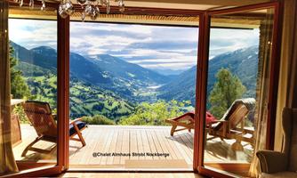 A cozy room with an open view of a breathtaking mountain landscape. The large windows let in plenty of daylight and offer a wonderful vista.