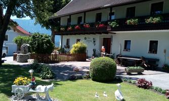 A charming guesthouse with a well-maintained garden. Colorful flowers and decorative figures give the surroundings an inviting atmosphere.