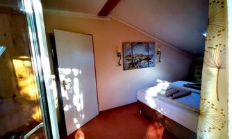 A cozy bedroom with a large bed and soft colors. Light streams through a window, creating an inviting atmosphere.