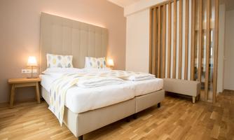 A modern bedroom with a large double bed, soft color tones, and refined wooden details. The atmosphere feels inviting and cozy.