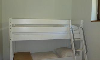 The children's room with a bunk bed, a cabinet, and an area for playing.