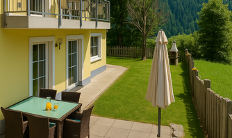 A cozy terrace with a table and chairs, surrounded by a beautiful lawn. In the background, green mountains can be seen.