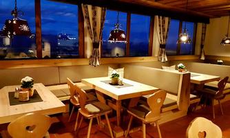 A cozy restaurant with wooden tables and chairs. The warm light sources create an inviting atmosphere.