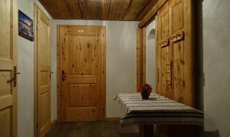 A cozy hallway with wooden paneling and a tablecloth. On one wall, there is a small flower on a table.