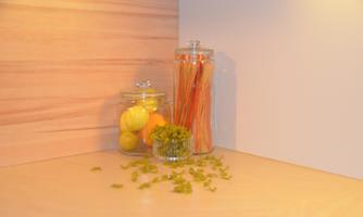 A beautiful kitchen corner with jars full of lemons and herbs. Colorful spaghetti stands in another jar and fresh leaves lie on the surface.
