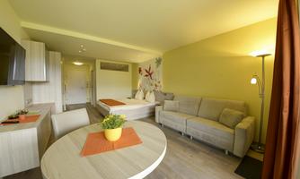 A modern room with a cozy sofa and a round table. Bright walls and a friendly atmosphere create an inviting ambiance.