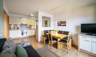 A bright and modern apartment with an open kitchen and dining area. The space is friendly furnished and offers a cozy atmosphere.