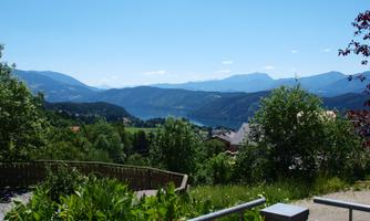 A beautiful landscape with green hills and mountains in the background. The sky is clear and blue.