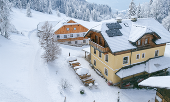 A snow-covered landscape featuring two charming buildings. The winter has made the surroundings peaceful and calm.