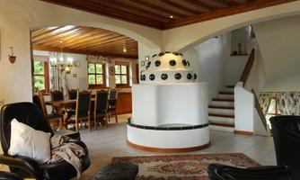 A spacious living room with an elegant dining area and a staircase. A cozy seating area is also available, with a modern fireplace in the middle.