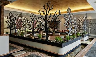 A modern interior design with stylized trees in black and white.  
Green plants and soft lighting create an inviting atmosphere.