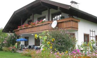 A beautiful house with a balcony and colorful flowers in the garden. The surroundings are inviting and friendly.