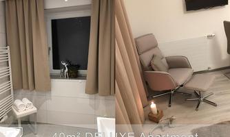 A modern 40m² deluxe apartment with elegant furniture and a cozy atmosphere. The large windows offer a view of the outdoors and the stylish decor ensures comfort.