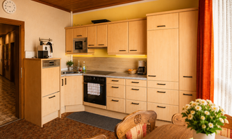A modern kitchen with light wood cabinets and an elegant countertop. The room is well-lit and invites cooking.
