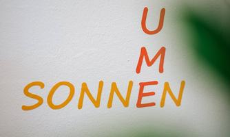 A wall with the inscription "BLUMENSONNEN". The letters are arranged in different colors.