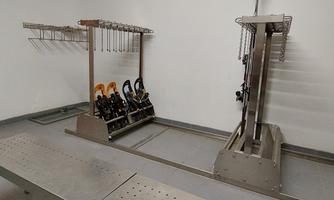 A modern workshop with metal shelves and brackets for equipment. The walls are white and the floor is gray.
