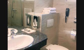 A modern bathroom with bright tile design. It includes a sink, a toilet, and a shower.