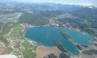 A breathtaking landscape with clear lakes and green meadows. In the background, the snow-capped mountains can be seen.